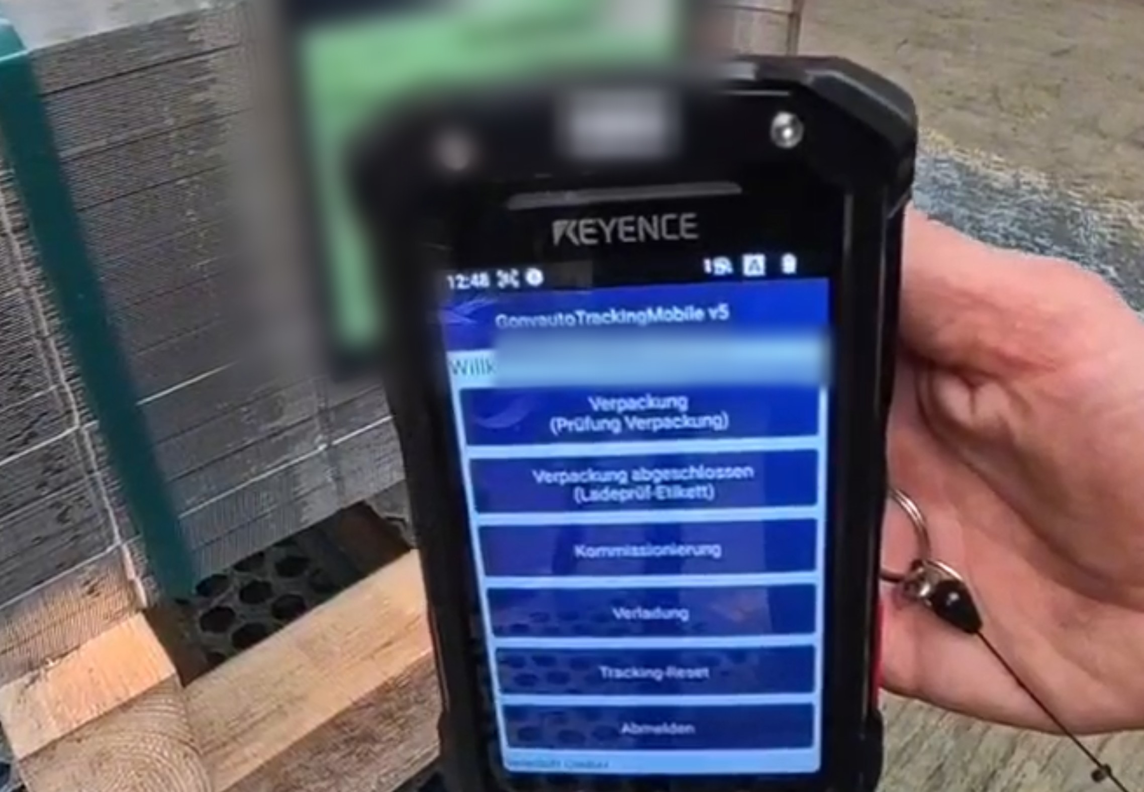 Menü der mobilen Track-&-Trace-App auf einem Keyence-Handheld mit den Prüfschritten Verpackung, Kommissionierung und Verladung